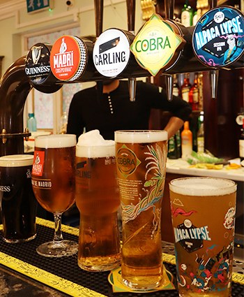 Pints being poured from the beer taps